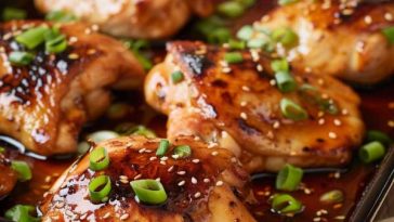 Golden baked teriyaki chicken thighs glazed with a sticky soy-ginger sauce, garnished with sesame seeds and scallions.