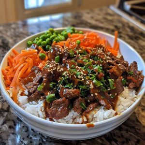 Easy Korean beef bowl with savory ground beef, steamed rice, sliced green onions, sesame seeds, and a drizzle of soy garlic sauce, served in a ceramic bowl.