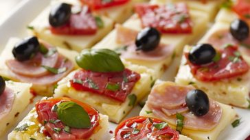 Layered antipasto squares with deli meats, cheese, and vegetables baked between flaky pastry.
