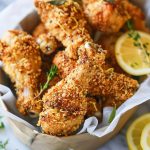 Crispy crunchy lemonade chicken drumsticks with golden coating, glazed in a tangy lemon sauce and garnished with fresh herbs.