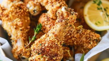 Crispy crunchy lemonade chicken drumsticks with golden coating, glazed in a tangy lemon sauce and garnished with fresh herbs.