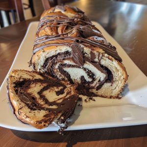 Homemade chocolate babka with twisted layers of soft bread and rich chocolate filling, sliced to show swirls.