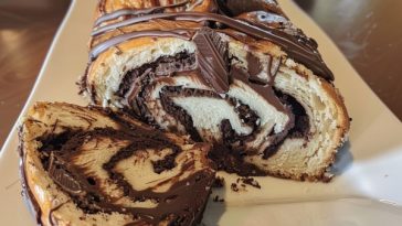 Homemade chocolate babka with twisted layers of soft bread and rich chocolate filling, sliced to show swirls.