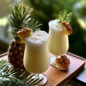 Pina colada cocktail with pineapple slice and cherry garnish