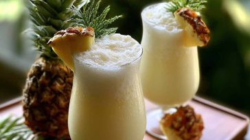 Pina colada cocktail with pineapple slice and cherry garnish