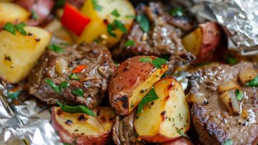 Juicy steak and tender potatoes cooked in foil packets with herbs and butter, ready to serve.