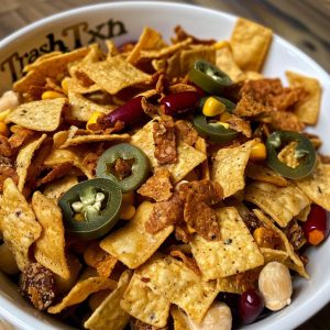 Crunchy Texas trash mix snack with cereal, pretzels, nuts, and crackers coated in a savory seasoned butter mixture.