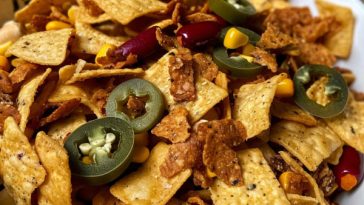 Crunchy Texas trash mix snack with cereal, pretzels, nuts, and crackers coated in a savory seasoned butter mixture.