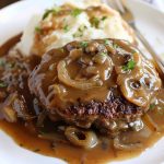 Juicy hamburger steak topped with caramelized onions and rich brown gravy.
