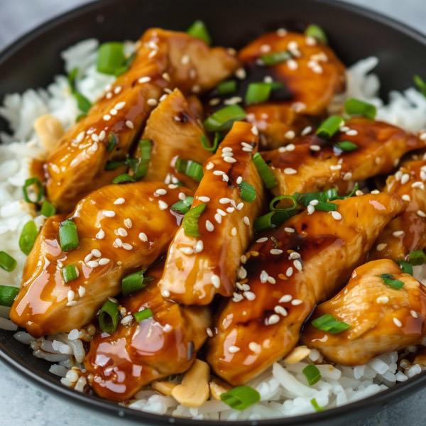 Teriyaki chicken glazed with shiny sauce, served with rice and vegetables.