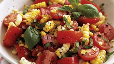 Fresh corn and tomato salad with juicy cherry tomatoes, sweet corn kernels, herbs, and a light vinaigrette in a bowl.