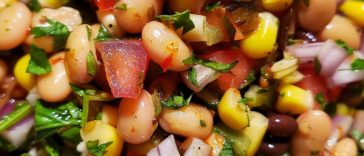 Colorful cowboy caviar made with black beans, corn, tomatoes, avocado, and peppers tossed in a fresh dressing.