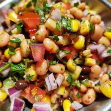 Colorful cowboy caviar made with black beans, corn, tomatoes, avocado, and peppers tossed in a fresh dressing.
