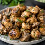Low carb mushroom chicken bites cooked in a savory garlic sauce with fresh herbs and sautéed mushrooms.