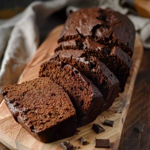 Rich chocolate pound cake with a moist crumb, sliced and served with a glossy chocolate glaze.