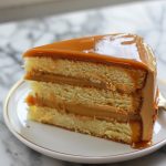 Moist caramel cake layered with rich caramel frosting and drizzled with glossy caramel sauce.