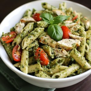 Pesto pasta with grilled chicken, fresh basil, and parmesan cheese tossed in a vibrant green sauce.