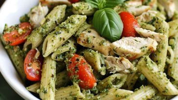 Pesto pasta with grilled chicken, fresh basil, and parmesan cheese tossed in a vibrant green sauce.