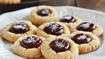 Buttery thumbprint cookies filled with jam centers and lightly dusted with powdered sugar.