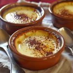 Creamy Spanish natillas custard topped with cinnamon and a traditional biscuit.