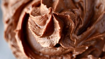 Bowl of creamy homemade chocolate buttercream frosting with swirls of rich texture