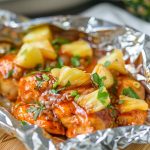 Juicy BBQ chicken foil pack with pineapple chunks, bell peppers, and sauce, cooked to perfection in a foil packet.