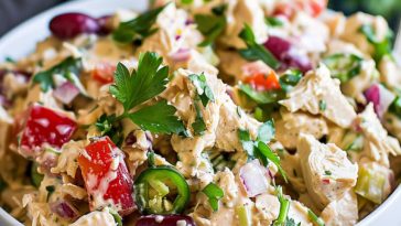 Classic creamy chicken salad served in a bowl with fresh herbs.