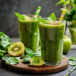 Refreshing green smoothie made with spinach, banana, and fruit blended into a creamy healthy drink in a glass.