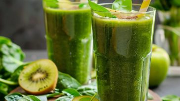 Refreshing green smoothie made with spinach, banana, and fruit blended into a creamy healthy drink in a glass.