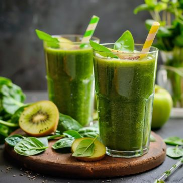 Refreshing green smoothie made with spinach, banana, and fruit blended into a creamy healthy drink in a glass.