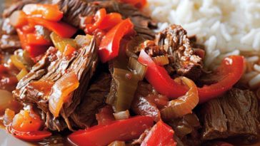 Tender slow-cooker pepper steak served over rice with colorful bell peppers.