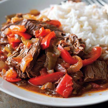 Tender slow-cooker pepper steak served over rice with colorful bell peppers.