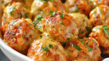 Cheesy chicken meatballs baked until golden, with melted cheese inside and herbs on top.