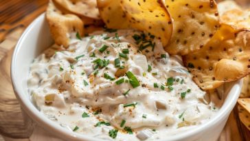 Creamy French onion dip with caramelized onions served with chips.