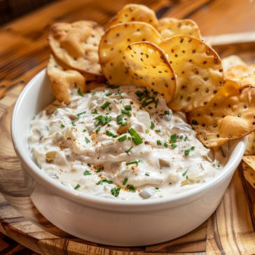 Creamy French onion dip with caramelized onions served with chips.