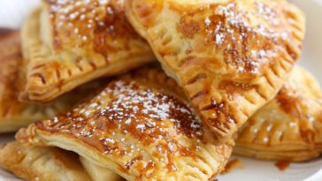 Golden apple turnovers filled with cinnamon apples and flaky pastry, lightly glazed on top.