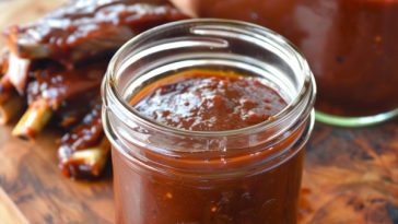 Homemade BBQ sauce simmering in a pot with a rich, glossy texture and deep smoky color.