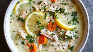 Bowl of lemony Greek chicken soup with rice, tender chicken, and fresh herbs.