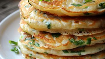 Golden flaky scallion pancakes sliced and served with dipping sauce.