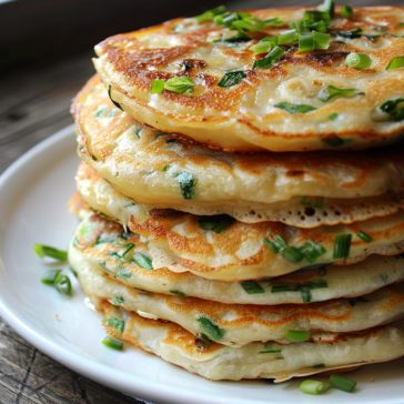 Golden flaky scallion pancakes sliced and served with dipping sauce.