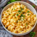 A creamy pot of homemade mac and cheese with elbow pasta coated in rich cheese sauce, served hot in a rustic pot and topped with extra melted cheese.
