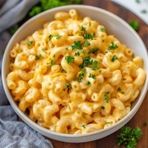 A creamy pot of homemade mac and cheese with elbow pasta coated in rich cheese sauce, served hot in a rustic pot and topped with extra melted cheese.