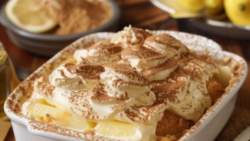 Layered lemon tiramisu with creamy mascarpone filling, lemon-soaked ladyfingers, and a light dusting on top.