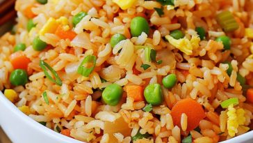 Easy fried rice with vegetables, eggs, and soy sauce, stir-fried in a pan until flavorful.