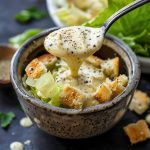 Creamy homemade Caesar salad dressing with garlic, parmesan cheese, and anchovy blended until smooth.