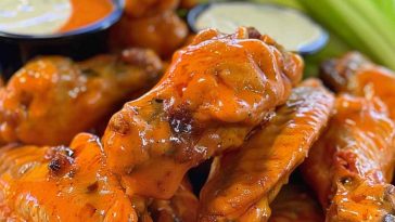 Crispy buffalo chicken wings coated in spicy sauce, served with celery sticks and a side of creamy ranch dressing.