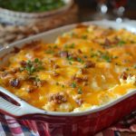 A golden-baked Amish breakfast casserole filled with eggs, sausage, hash browns, and melted cheese, sliced into squares and served on a rustic plate.