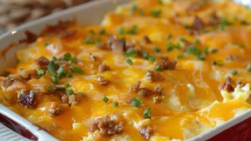 A golden-baked Amish breakfast casserole filled with eggs, sausage, hash browns, and melted cheese, sliced into squares and served on a rustic plate.