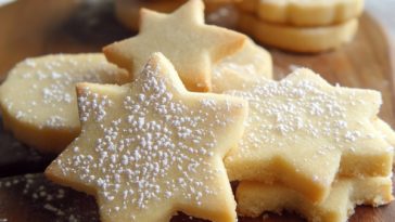 Buttery shortbread cookies with a golden crumb, lightly dusted with sugar and arranged on a plate.