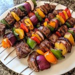 Juicy steak kebabs grilled with colorful bell peppers, onions, and zucchini, brushed with savory marinade.